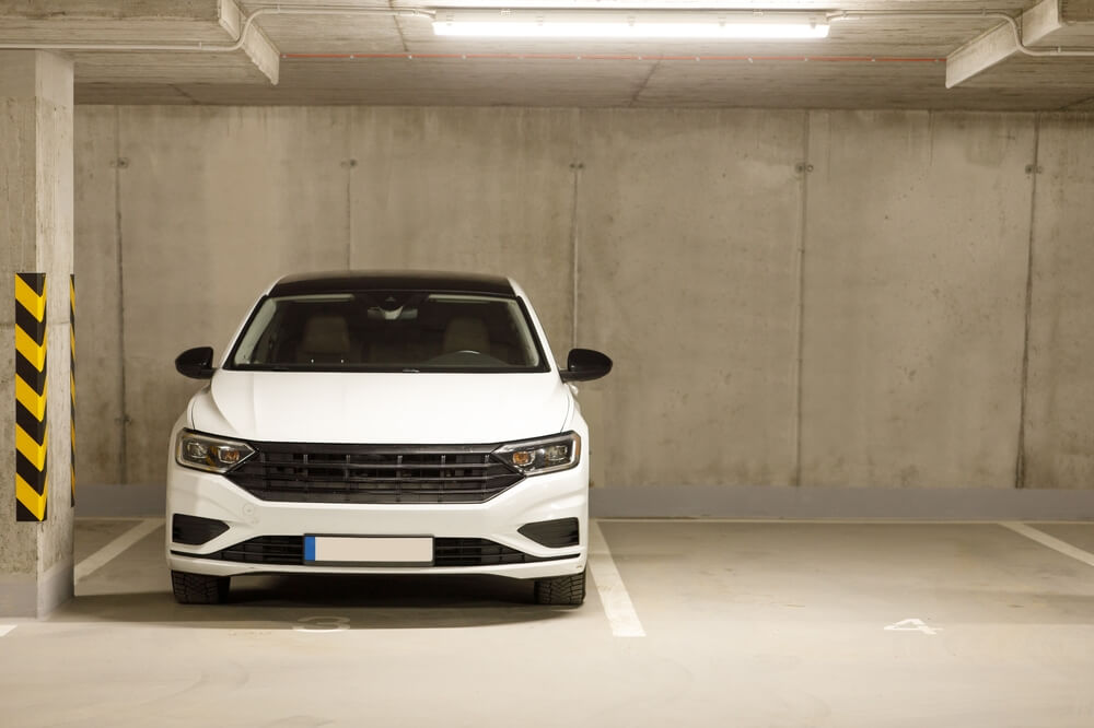 Kapalı otoparkta park edilmiş beyaz otomobil